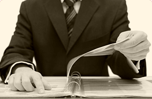 Мужчина в деловом костюме пристально изучает папку с документами