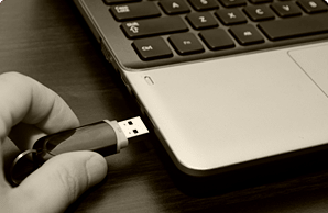 Флеш-накопитель, поднесенный к USB порту ноутбука